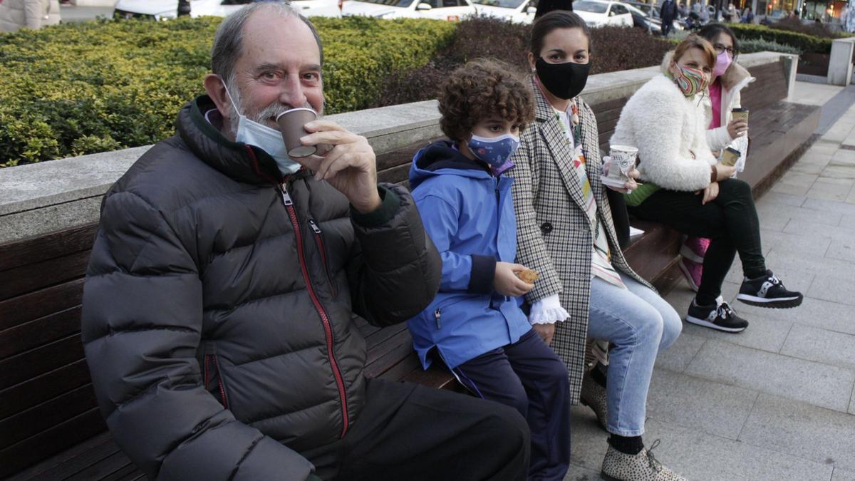 Un grupo de gijoneses, con el café para llevar en la calle