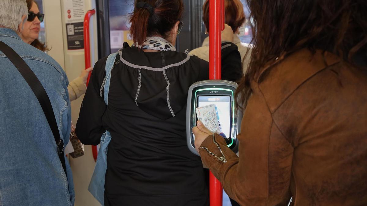 Una usuaria valida su tarjeta al subir al tranvía.