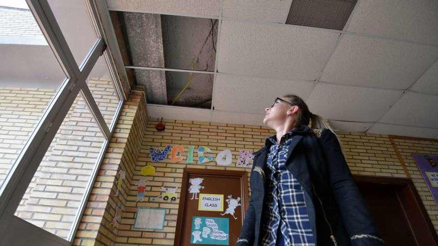Una miembro del ANPA enseña una placa de amianto a la vista en el interior del colegio. // Gustavo Santos