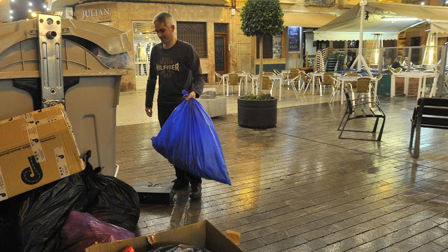 Un contenedor de la Replaceta de la Fregassa durante estas navidades, a rebosar de basura y con bolsas en el suelo, a primera hora de la noche.