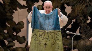 El papa besa una bandera de Ucrania llegada desde Bucha.