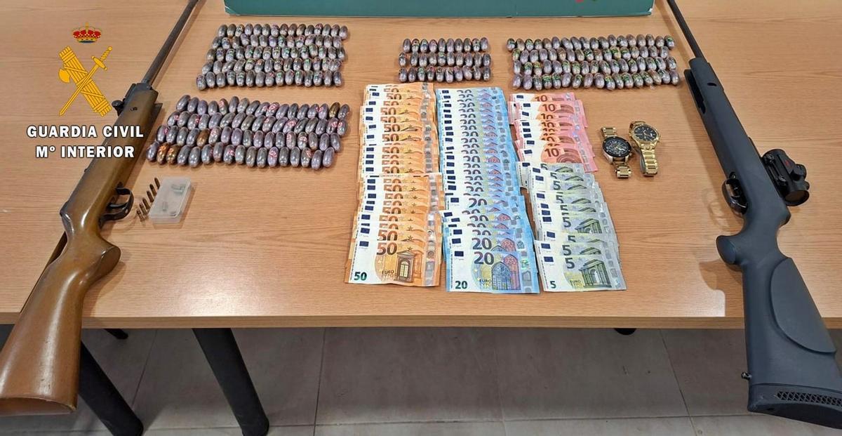 Parte del material intervenido durante la operación, con las dos carabinas, dinero en efectivo y las bellotas de hachís requisadas.