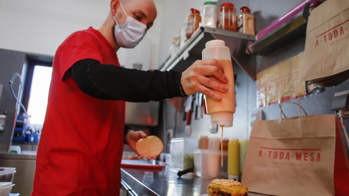 Preparando una hamburguesa ASPAYM en las cocinas de &quot;A toda mesa&quot;.