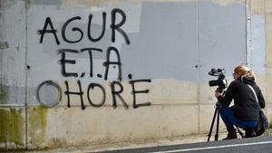 zentauroepp43164297 a woman takes images of a graffiti reading in basque  eta  f180503134607