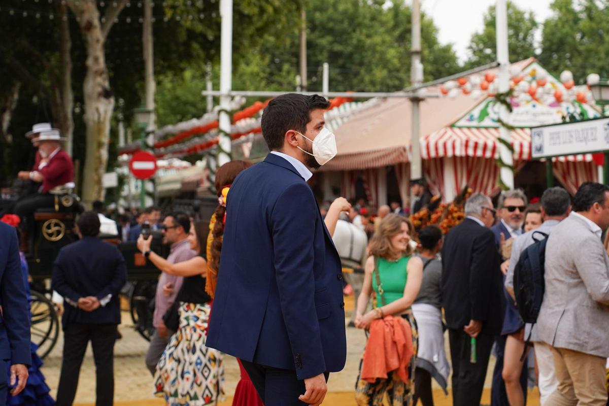 Una persona con mascarilla andando en la Feria de Sevilla