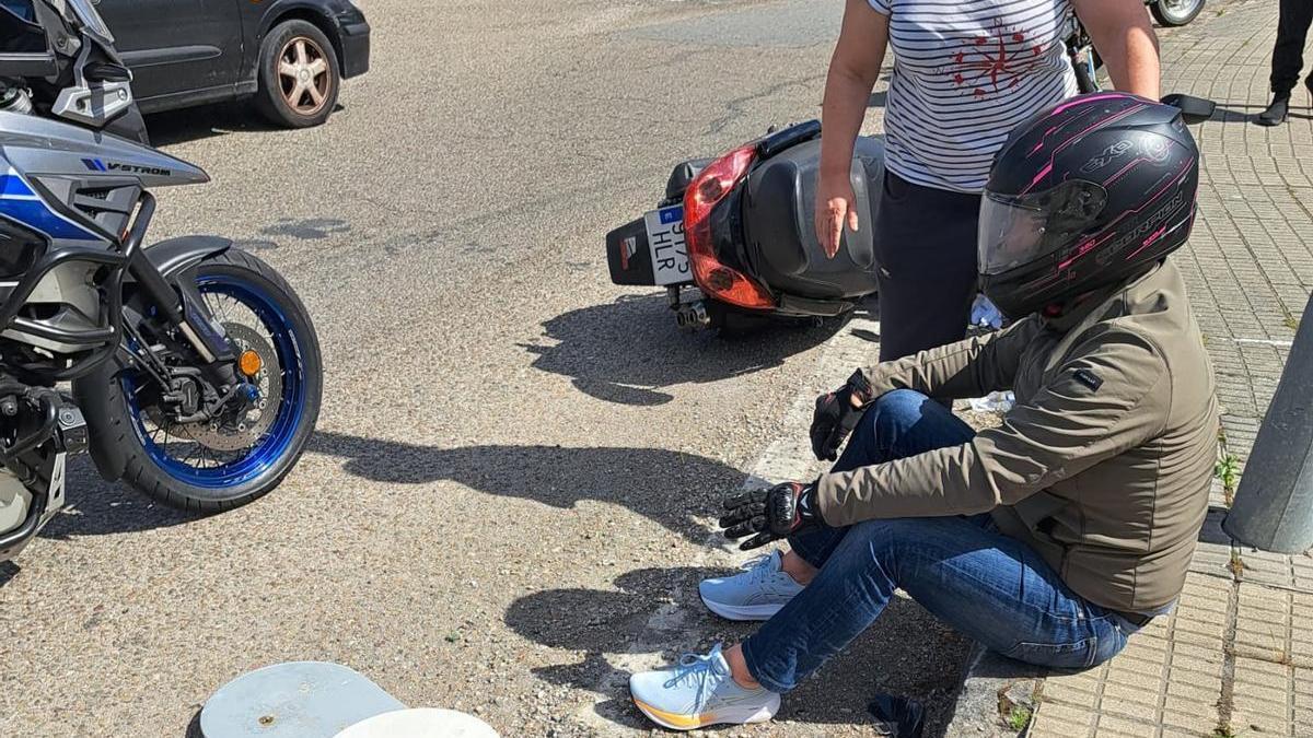 Motociclista accidentado sentado en el arcén con la luminaria a su lado