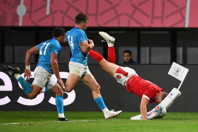 El ala de Gales, Hallam Amos (R), pierde el balón cuando el medio scrum uruguayo Agustín Ormaechea (L) y el ala Leandro Leivas corren tras él durante el partido de la Copa Mundial de Rugby de Japón 2019 D entre Gales y Uruguay en el estadio Kumamoto