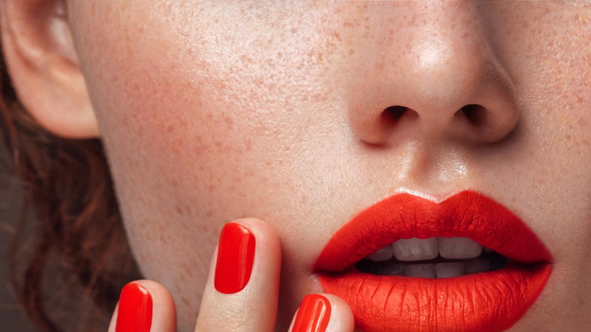 Mujer con manicura y labios en rojo