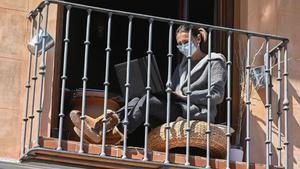 Imagen de archivo de una mujer trabajando en el balcón de su casa en plena cuarentena.