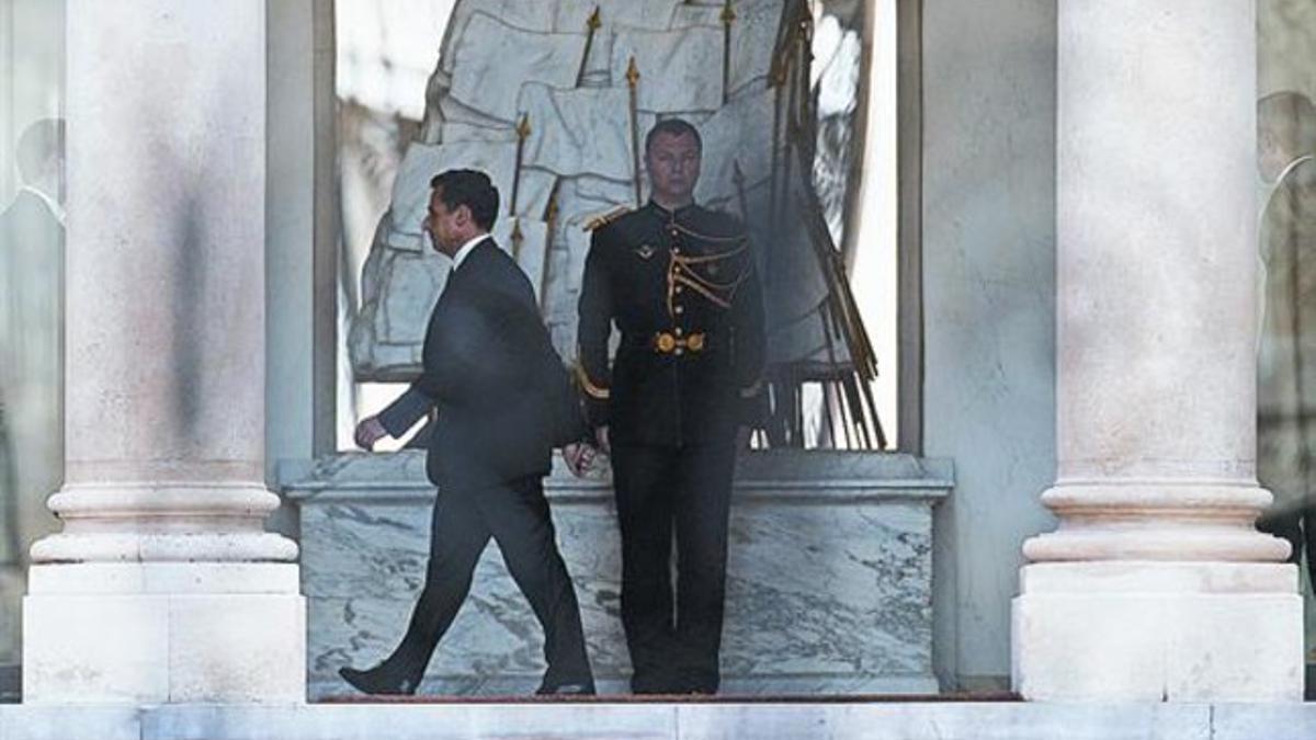 El presidente saliente, Nicolas Sarkozy, camina, solo, en el palacio del Elíseo, ayer.