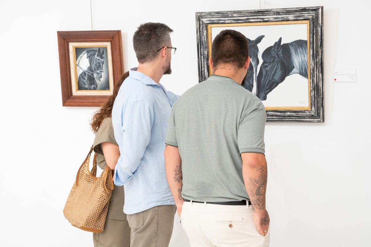 Visitantes y autoridades recorren en la Asamblea de Extremadura la exposición "Mi tierra, mis gentes", del pintor emeritense Francisco Miranda.