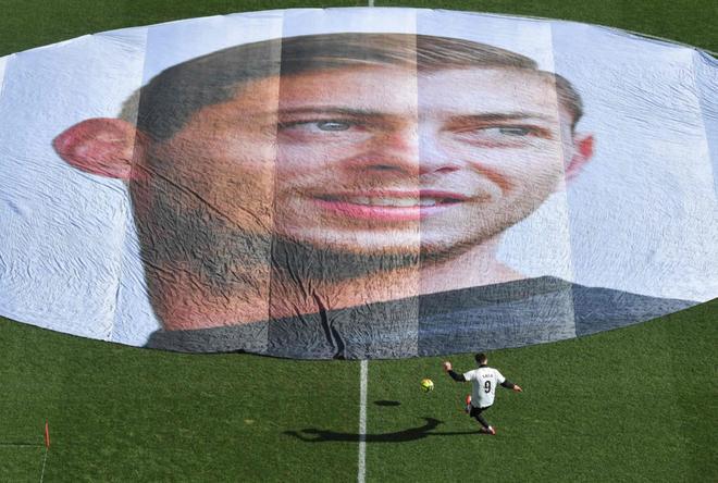 Un jugador entrena frente al retrato del delantero argentino Emiliano Sala antes del partido de fútbol L1 entre FC Nantes y Nimes (ON) en el Estadio Beaujoire en Nantes.