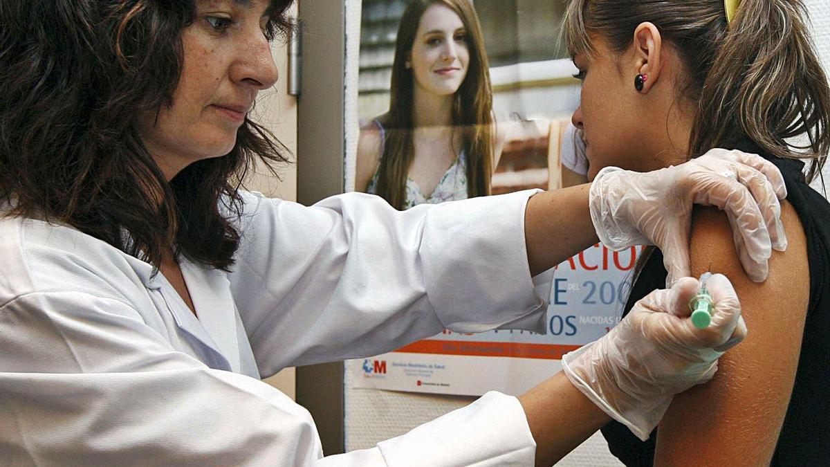 33 Una enfermera vacuna a una joven contra el virus del papiloma humano, hace unos años.  | EL PERIÓDICO