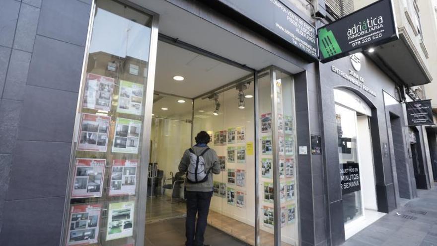Un joven consulta la oferta de vivienda de una inmobiliaria de Zaragoza. | EL PERIÓDICO