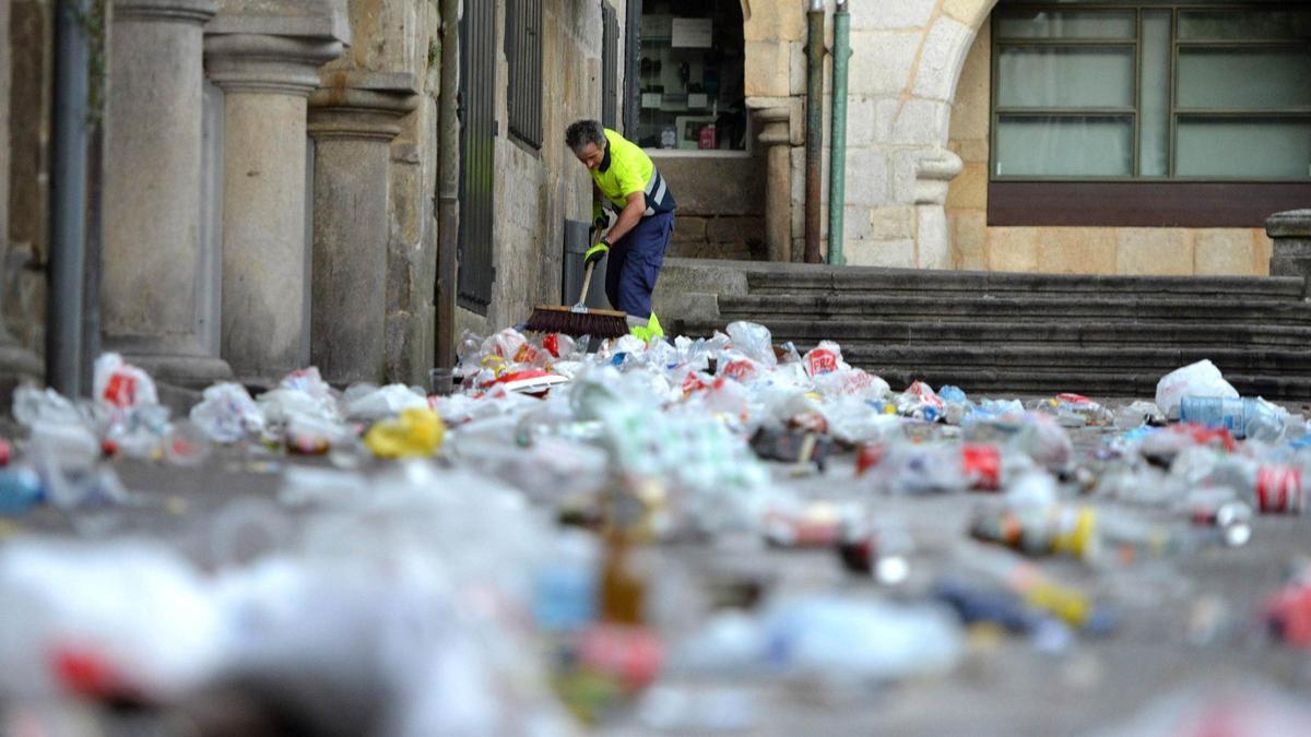 Un operario limpia los restos de un botellón.