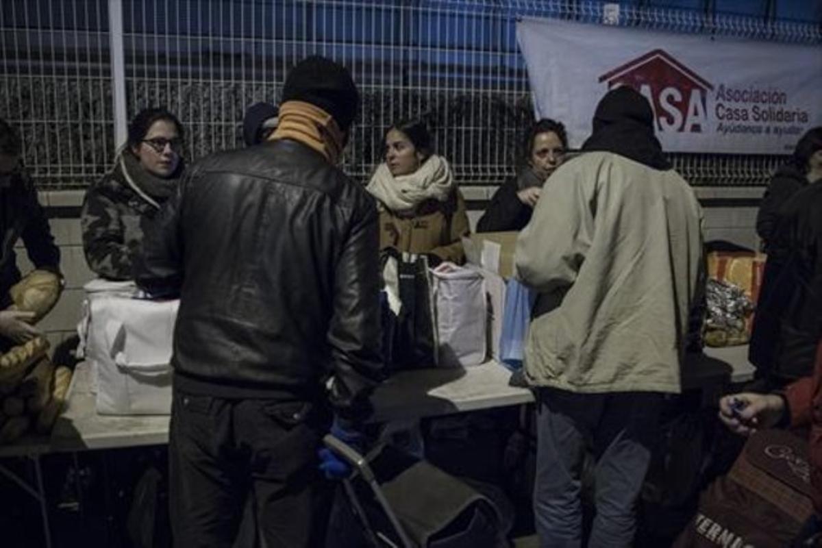 Voluntàries de Casa Solidària entreguen el sopar a uns usuaris. Voluntàries de Casa Solidària entreguen el sopar a uns usuaris.