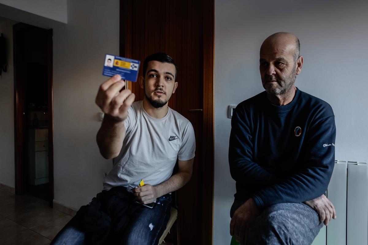 Karim Bouraada, con su padre Mustapha, muestra la tarjeta sanitaria de Melilla, con la que ahora, en Ripoll, se niegan a atenderle.