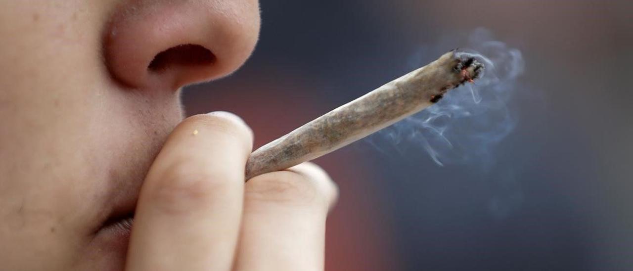 Un joven se fuma un porro de marihuana