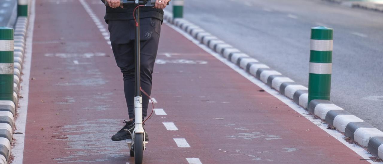 Un usuario circula con un patinete eléctrico por un carril bici de Elche