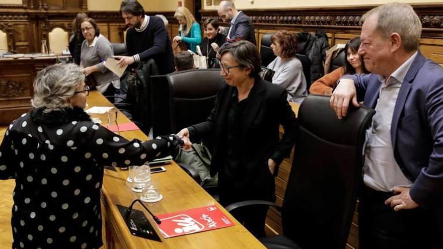 Ana González (PSOE) estrecha la mano de Yolanda Huergo (Podemos-Equo) ante la mirada de Aurelio Martín (IU), tras la aprobación del presupuesto municipal.