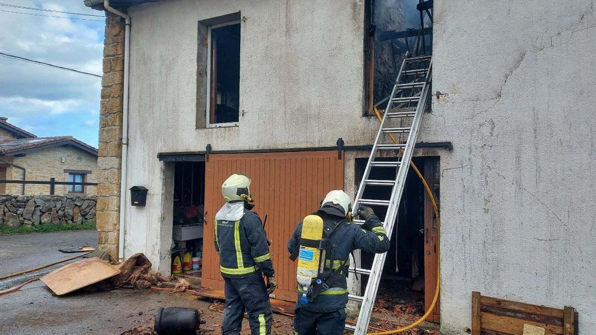 Los bomberos inspeccionan la vivienda tras extinguir el fuego.
