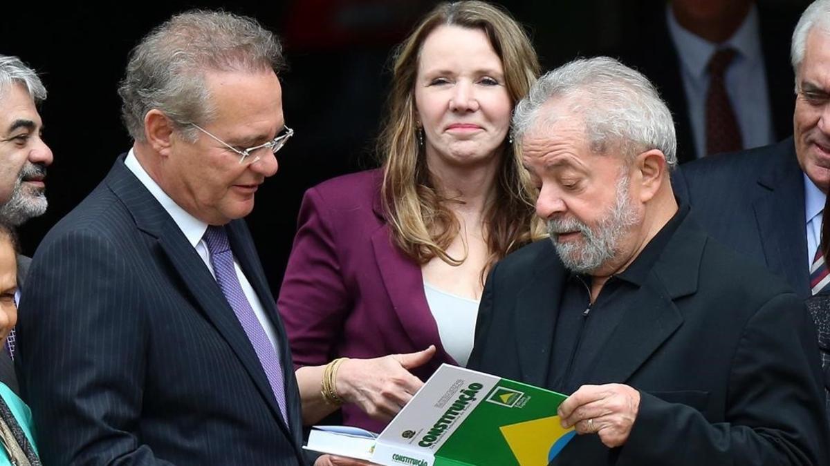 Lula da Silva (derecha) recibe un ejemplar de la Constitución de Brasil de manos del senador Renan Calheiros, tras una reunión con senadores del Partido del Movimiento Democrático de Brasil, en Brasilia, este miércoles.