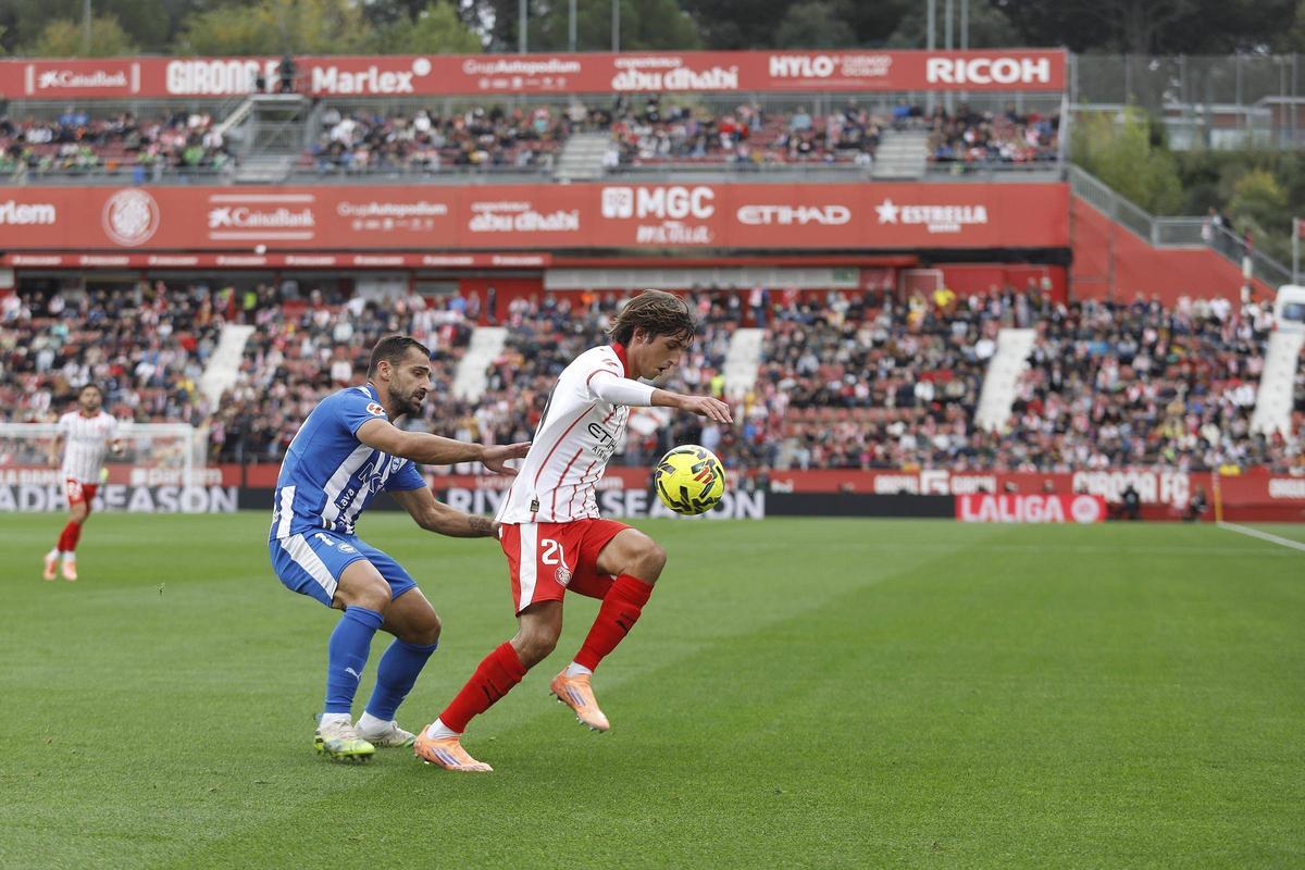 Bryan Gil protegeix una pilota davant la pressió de Jonny Otoo en el partit a Montilivi