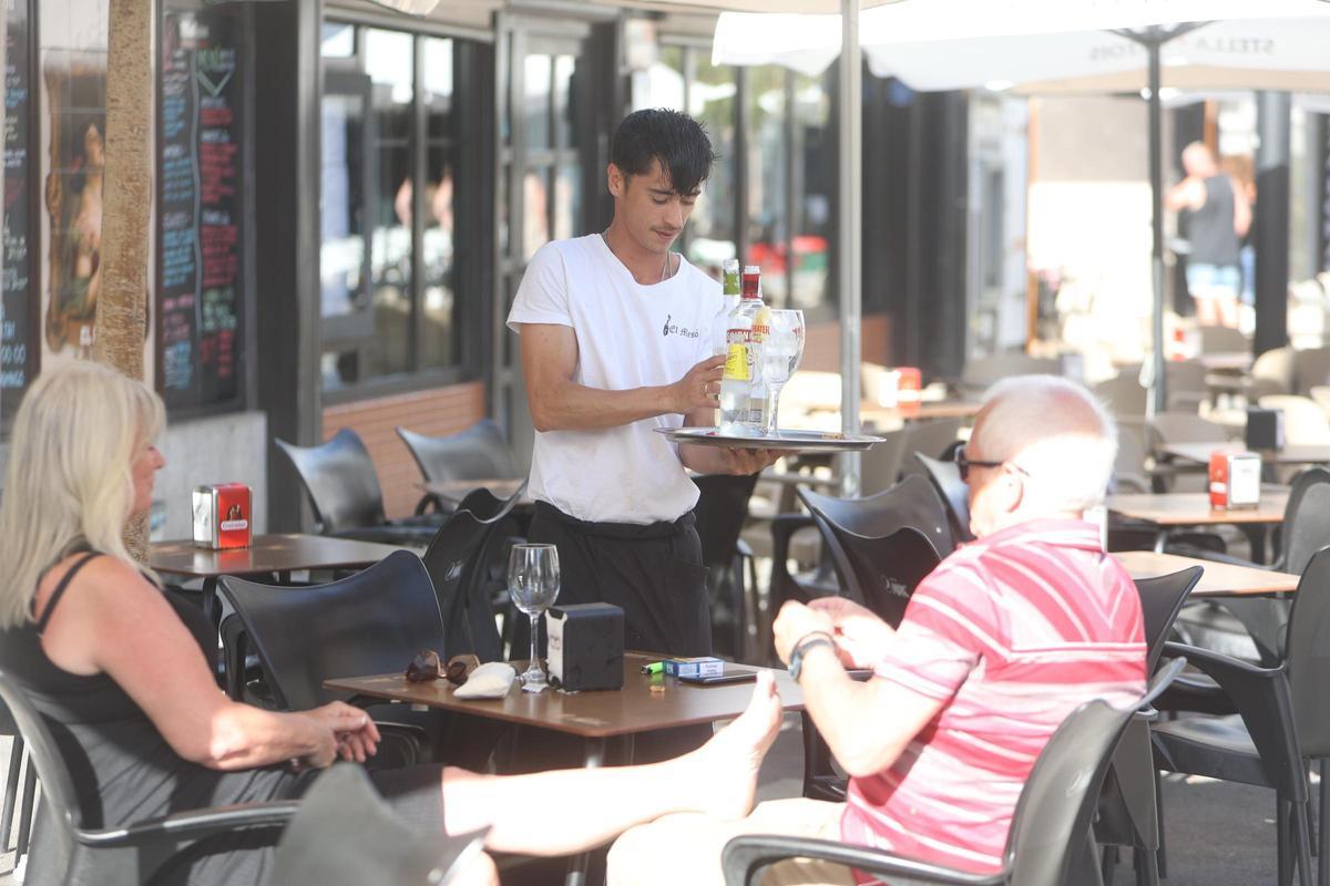 Un camarero atiende una mesa en Benidorm