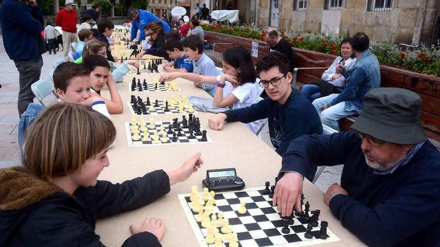 Nenos e adultos disputaron as partidas de xadrez que celebrarou a Asociación de Veciños Santa María e a Escola Xadrez. // Rafa Vázquez