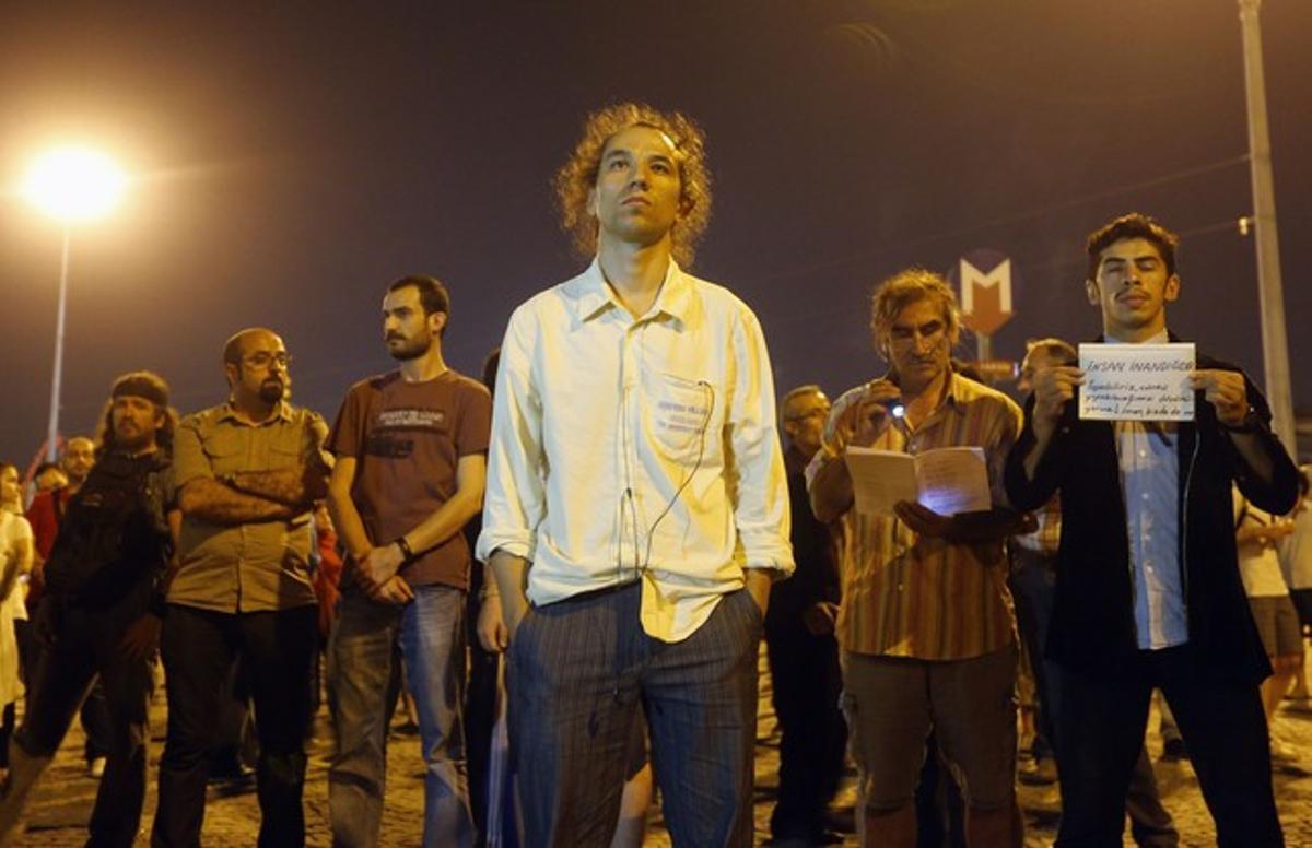 Manifestants turcs, drets i en silenci, a la plaça Taksim d’Istanbul, dilluns a la nit.