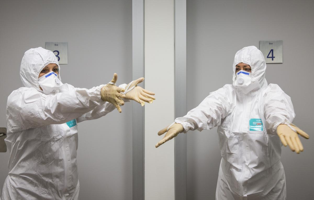 Dos sanitarios se protegen en un hospital de enfermedades infecciosas. 