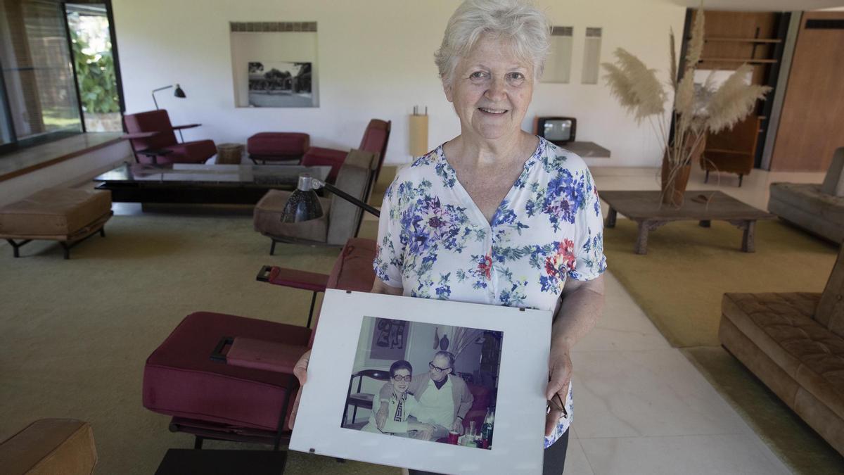 Marita Gomis, en la sala de estar de la Casa Gomis, sujeta una foto de sus padres tomada precisamente en esta misma estancia