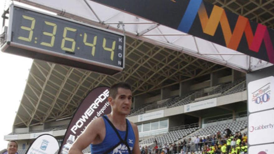 Un atleta llega a la meta tirando del carrito de su hijo.