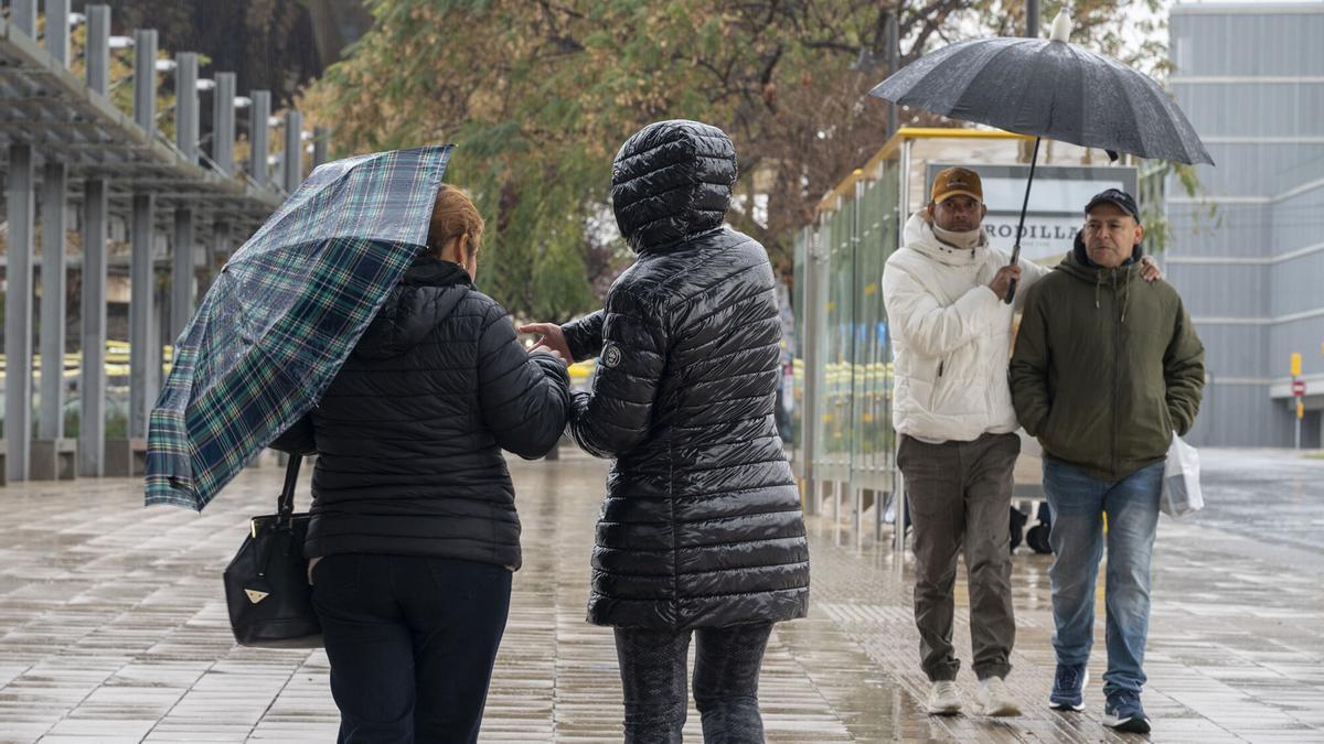 Personas caminando bajo la lluvia.