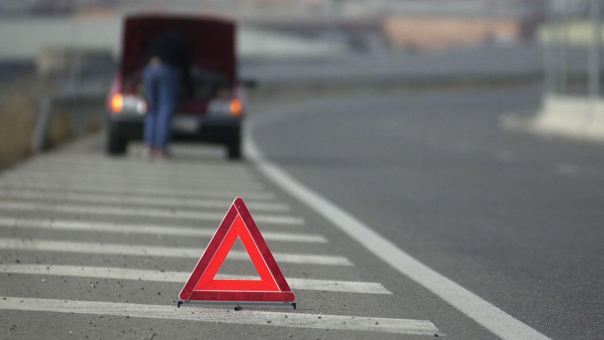 Un conductor señaliza con un triángulo de emergencia una avería en su coche