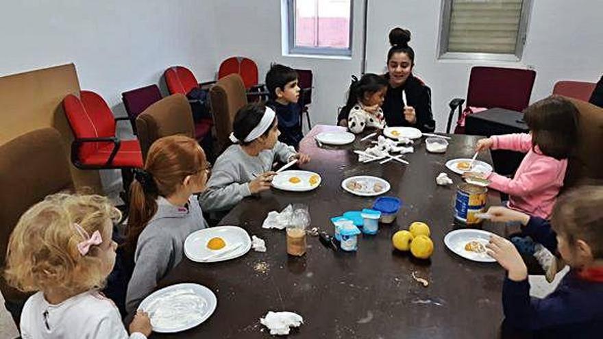 Los niños se manchan las manos cocinando en uno de los talleres organizados en Quintanilla del Monte.