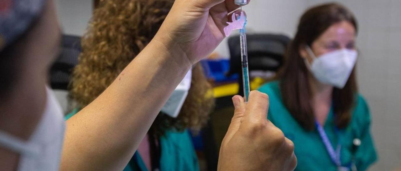 Una profesional sanitaria prepara una dosis de la vacuna contra el coronavirus. | | CARSTEN W. LAURITSEN