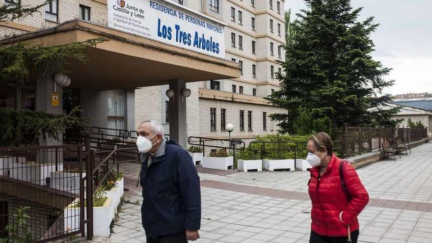 Dos personas pasean frente a la residencia Los Tres Árboles.