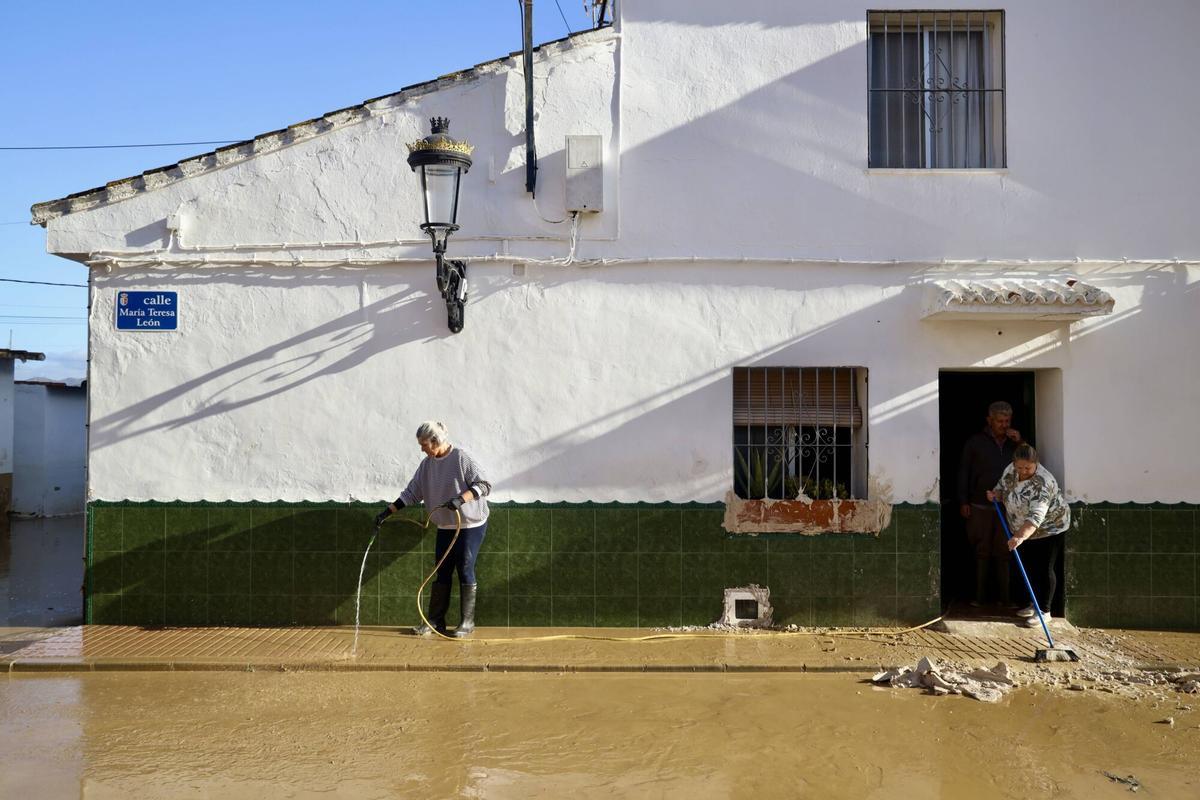 Los vecinos de la barriada de Doña Ana en la Estación de Cártama, junto al operarios Infoca, limpian los estragos de la nueva inundación provocada por la crecida del Guadalhorce durante la borrasca Francis