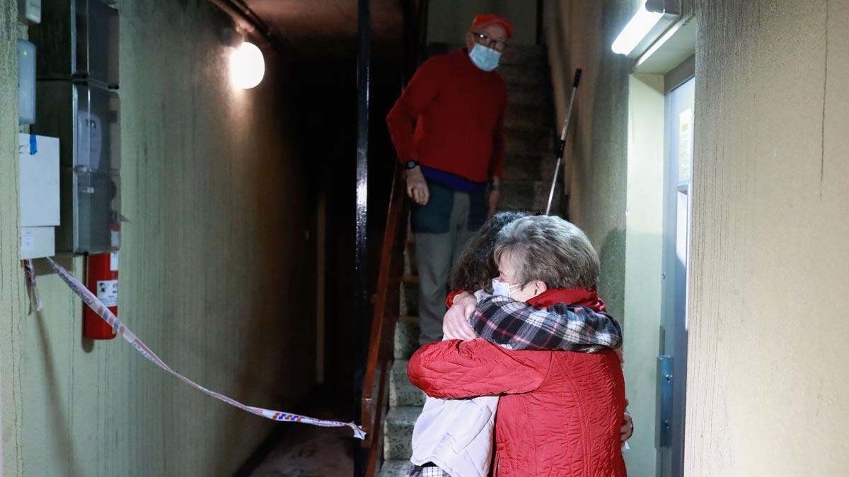 Vecinos de la finca en la que ha muerto una mujer tras un incendio, en Roquetes (Nou Barris), se abrazan llorando tras el susto por el suceso