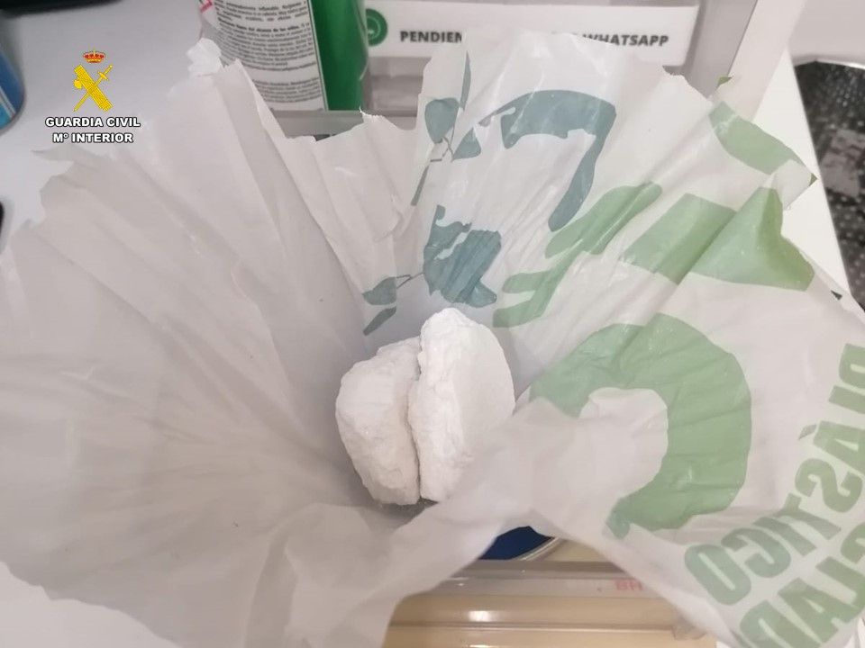 Bolsa con la droga y el dinero que lanzaron los arrestados por la ventanilla del coche.