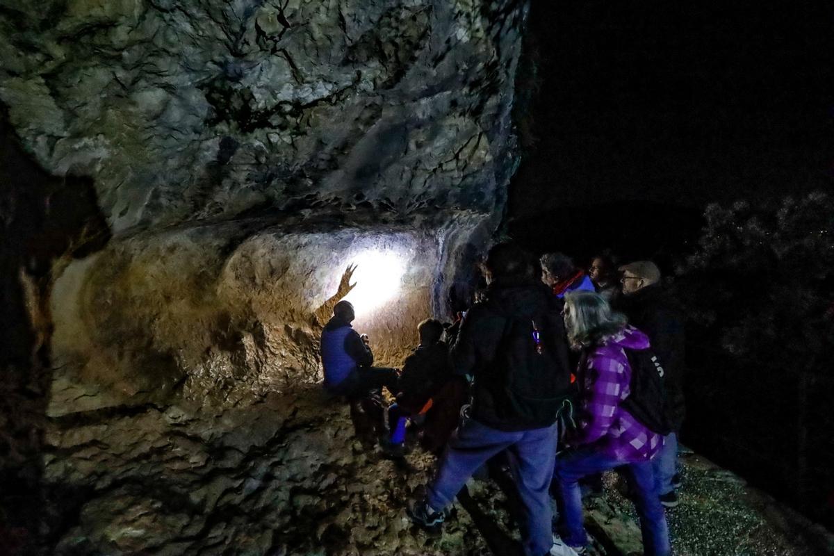 Uno de los guías explica a los participantes los distintos motivos de este abrigo de La Sarga