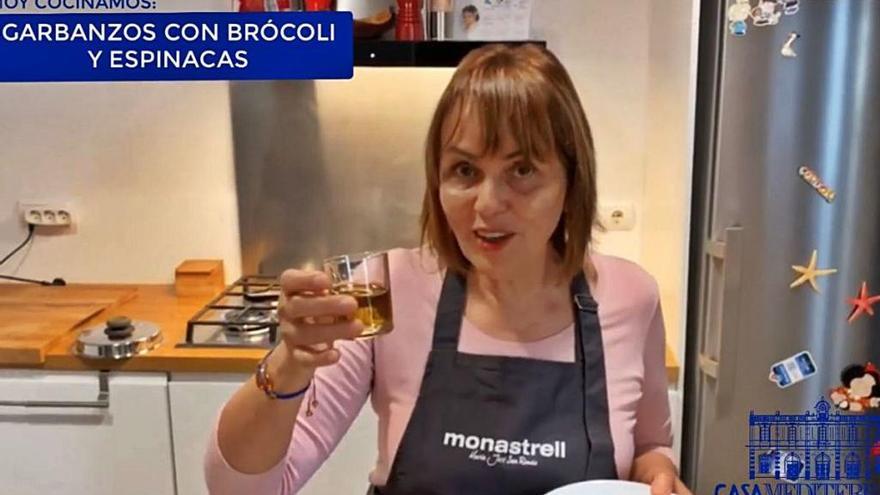 María José San Román, durante la grabación de la receta, con un vaso de aceite de oliva virgen extra.