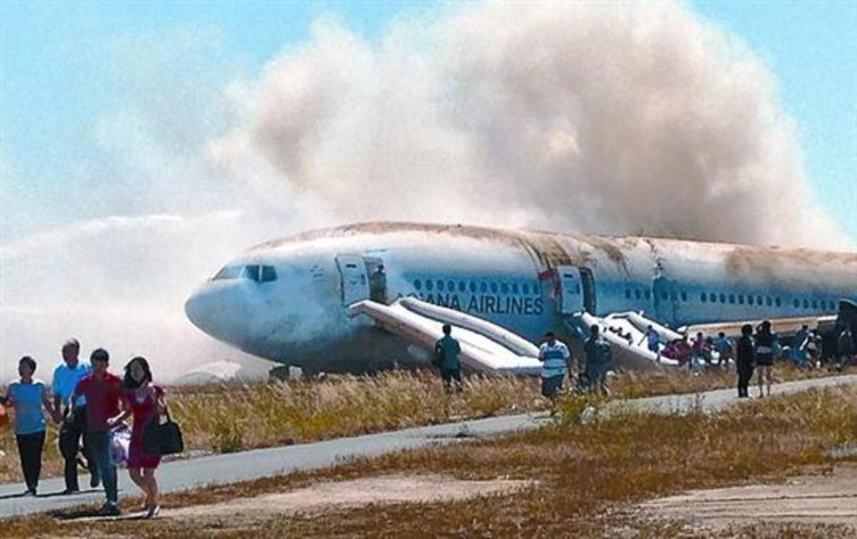 Els passatgers del vol d’Asiana abandonen l’avió després d’incendiar-se, dissabte, a San Francisco,