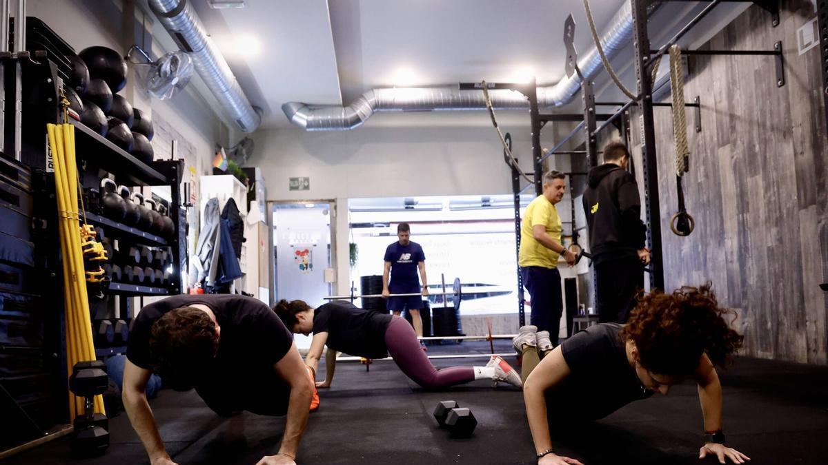 Varias personas practican deporte en un gimnasio