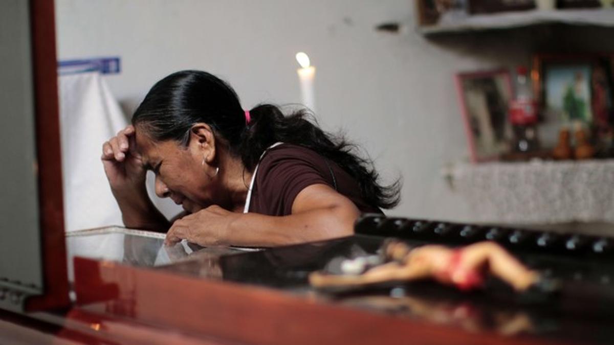 Una mujer llora sobre el féretro de Miguel Ángel Jiménez, este domingo en Xaltianguis.