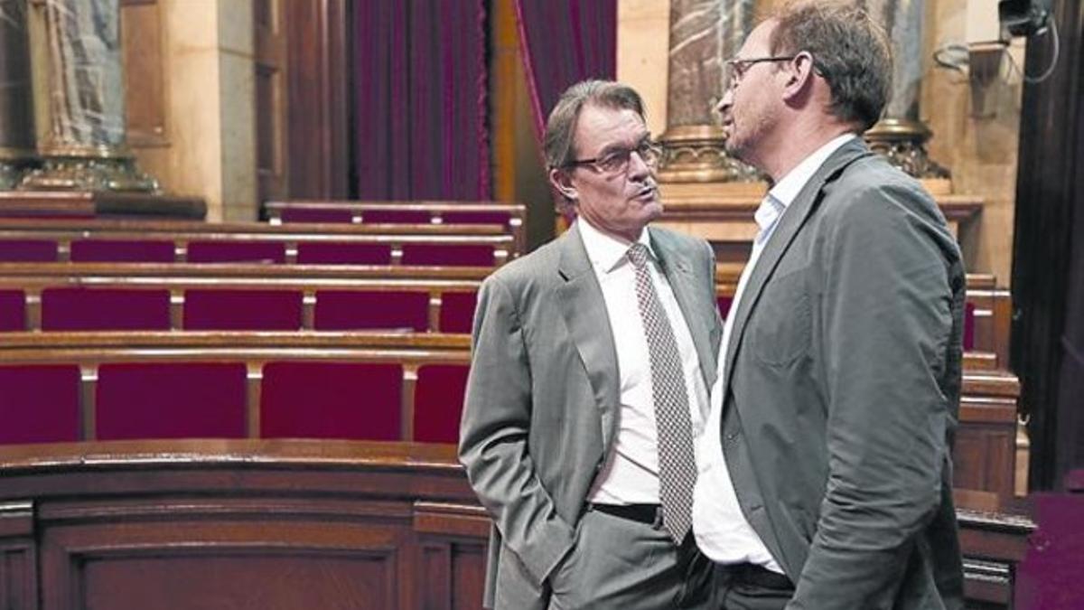 El 'president', Artur Mas, y el líder de ICV-EUiA, Joan Herrera, en el hemiciclo del Parlament.