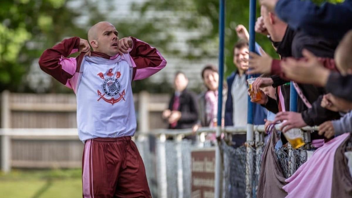 Jamie Byatt celebra un gol con el Corinthian-Casuals FC mostrando el escudo del Corinthians Paulista