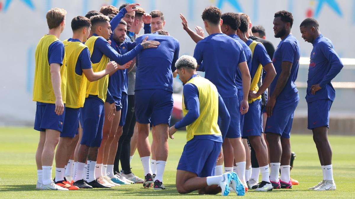 Araujo, arrodillado junto al túnel de collejas por el que pasa Christensen antes del inicio del entrenamiento.