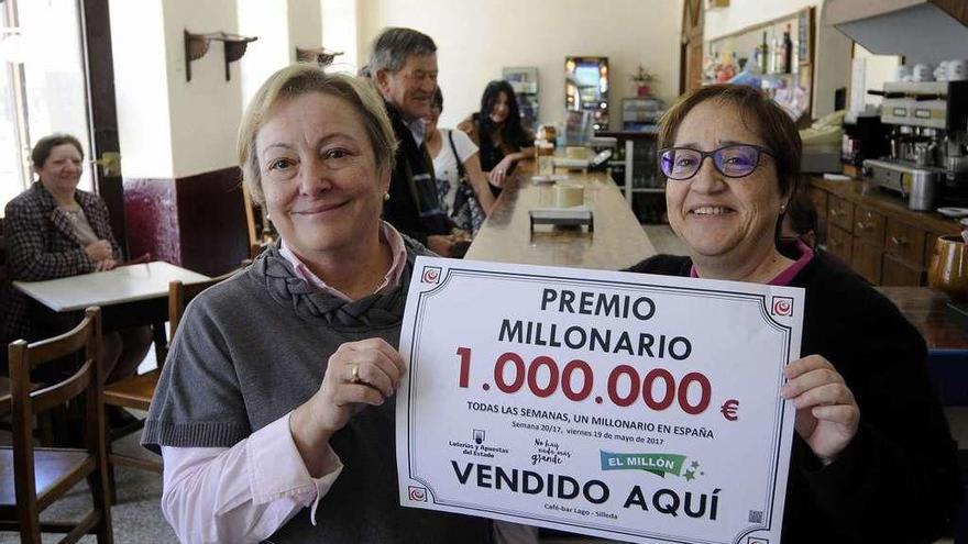 María del Carmen Castro, a la derecha, sujeta junto a su cuñada el cartel del premio. // Bernabé/Javier Lalín